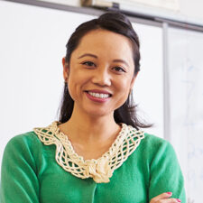 Portrait of confident Asian female teacher in classroom